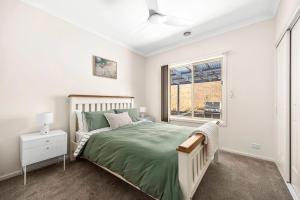 a bedroom with a bed and a window at Modern home in Highton in Highton