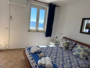 a bedroom with a bed with towels and a window at Ponzamania Terrazza sul tramonto in Ponza