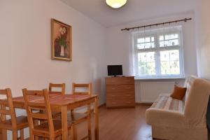 a living room with a dining room table and a chair at Pokoje Gościnne Perłowa in Kołobrzeg