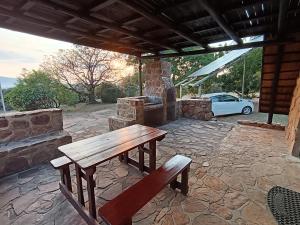 a wooden picnic table sitting on a stone patio at Cosy Cottage in Buffelspoort