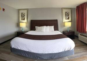 a hotel room with a large bed with two lamps at Western Inn in Forest Park