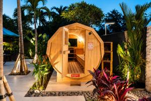 a small wooden hobbit house in a garden at Watermark Hotel & Spa Bali in Jimbaran