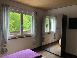 a bedroom with a bed and a window and a mirror at Appartements Dürnle in Mühldorf