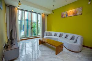 a living room with a couch and a tv at Lovina Heights in Mount Lavinia