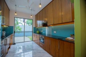 a large kitchen with wooden cabinets and a large window at Lovina Heights in Mount Lavinia