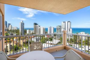 a balcony with a table and chairs and a view of the ocean at Belle Maison Apartments - Official in Gold Coast