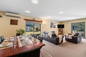 a dining room and living room with a table and chairs at Kickenback Lodge - 3BR Lodge l Gym l Indoor Pool l Tennis l WiFi l Air-Con in Crackenback