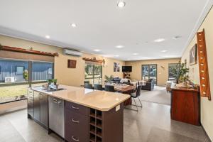 an open kitchen and living room with a table and chairs at Kickenback Lodge - 3BR Lodge l Gym l Indoor Pool l Tennis l WiFi l Air-Con in Crackenback