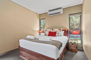 a bedroom with a large bed and a window at Kickenback Lodge - 3BR Lodge l Gym l Indoor Pool l Tennis l WiFi l Air-Con in Crackenback