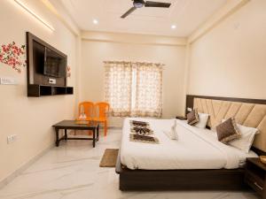 a bedroom with a bed and a table and a television at Hotel Ayodhya Dharshan 500m Walk From Shree Ram Mandir in Ayodhya