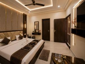 a bedroom with a large bed with a ceiling fan at Hotel Ayodhya Dharshan 500m Walk From Shree Ram Mandir in Ayodhya