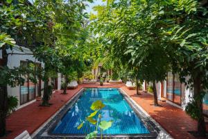 a swimming pool in a courtyard with trees at Le Sen Boutique Hotel in Luang Prabang