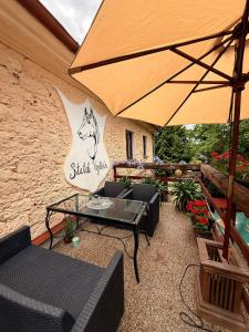 a patio with a table and an umbrella at Statek Vojtěšín in Vojtěšín