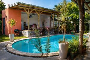 a swimming pool in front of a house with plants at Gite des Acacias in Union Vale
