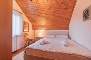 a bedroom with a bed with a wooden ceiling at House Marija with BBQ & Garden - Happy Rentals in Gradišča