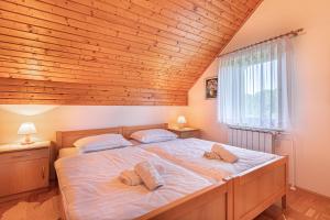 a bedroom with a large bed with a wooden ceiling at House Marija with BBQ & Garden - Happy Rentals in Gradišča +16 photos