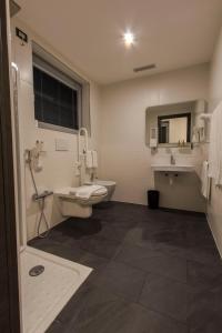 a bathroom with a toilet and a sink at Mito Hotel in Châtillon