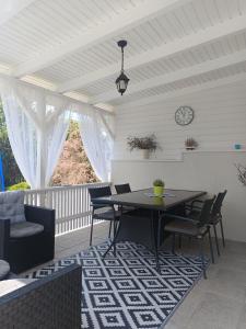 a dining room with a table and chairs on a porch at Bella Vita in Balatonfůzfő