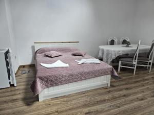 a bedroom with a bed with two towels on it at Apartament La Cetate in Aiud