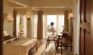 a bedroom with a bed and a table and a window at Binucot Pearl Boutique Resort in Ferrol