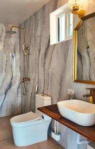 a bathroom with a sink and a toilet and a mirror at Binucot Pearl Boutique Resort in Ferrol