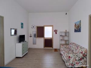 a living room with a couch and a television at Adamo Flat in Bisciano
