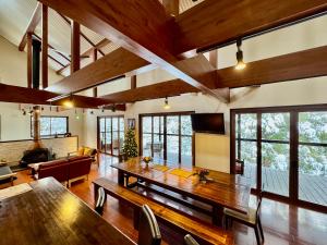 a large living room with a wooden table and chairs at Bears Den Mountain Lodge in Hakuba