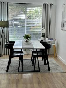 a dining room with a table and chairs and a window at Annie's Apartment in Mount Gambier