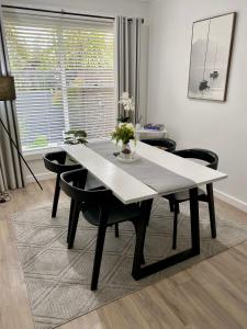 a dining room table with black chairs and a white table at Annie's Apartment in Mount Gambier