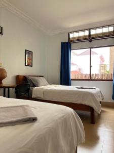 a hotel room with two beds and a window at Sorya Guesthouse & Dolphin Tours in Kratie
