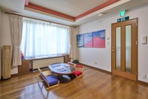 a living room with a table and chairs and a window at Sapporo Vacation Home B&B in Sapporo