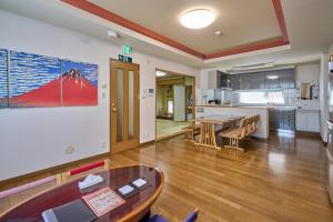 a living room with a table and a kitchen at Sapporo Vacation Home B&B in Sapporo