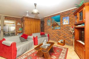 a living room with a couch and a brick wall at Bromeliads in Iluka