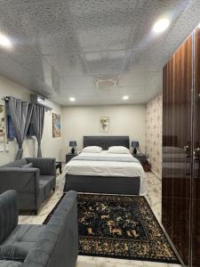 a bedroom with a large bed and a couch at Capresso Homes 4 in Islamabad +2 photos