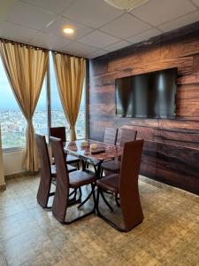 a dining room with a table and chairs and a flat screen tv at Capresso Homes 4 in Islamabad