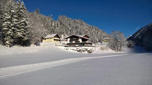 een huis in de sneeuw voor een berg bij Haus Herma in Bach