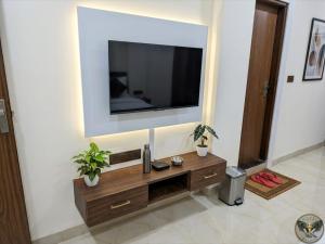 a living room with a television on a wall at Hotel cressida green palace - near redisson squar in Indore +34 photos
