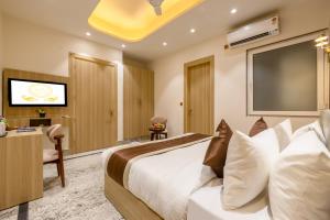 a hotel room with a bed and a flat screen tv at Hotel Silver Star in Greater Noida