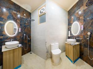 a bathroom with a toilet and a sink and mirrors at Hotel Silver Star in Greater Noida