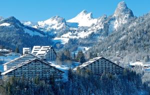 a ski lodge in the mountains with snow covered mountains at San's resort in Vionnaz