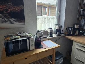 a microwave sitting on top of a wooden table at Tenneberger 1 in Ilsenburg +9 photos