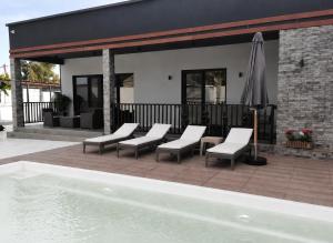 a group of chairs and an umbrella next to a pool at Sunnyside cottage Bilgah in Bilgah +21 photos