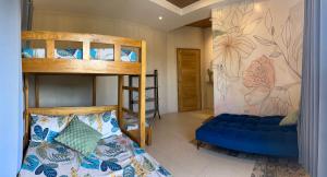 a room with two bunk beds and a blue couch at Villas Transient Inn in San Juan