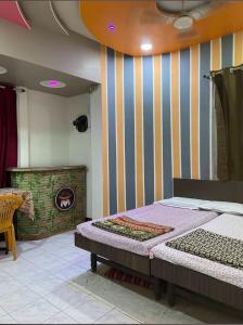 a bedroom with a bed and a striped wall at Muktai Lodge in Solapur
