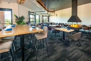 a room with tables and chairs and a fireplace at Chateau Cartier Hotel & Resort, an Ascend Collection Resort in Gatineau