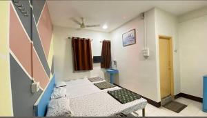 a hospital room with two beds and a window at Muktai Lodge in Solapur