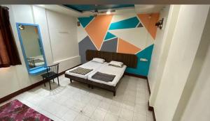 a bedroom with a bed and a colorful wall at Muktai Lodge in Solapur +13 photos