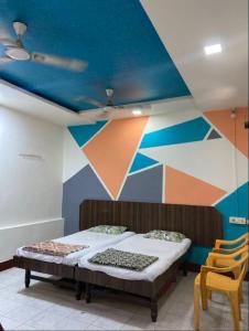 a room with two beds and a painted ceiling at Muktai Lodge in Solapur