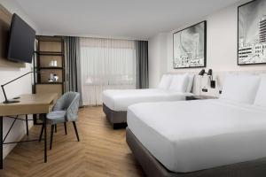 a hotel room with two beds and a desk at Radisson Blu Fargo in Fargo +69 photos