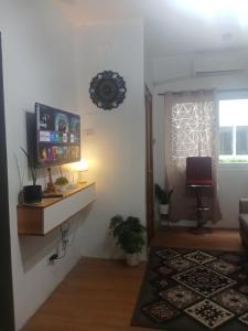a living room with a tv on a wall at Bayanihan flats Condo in Pajak